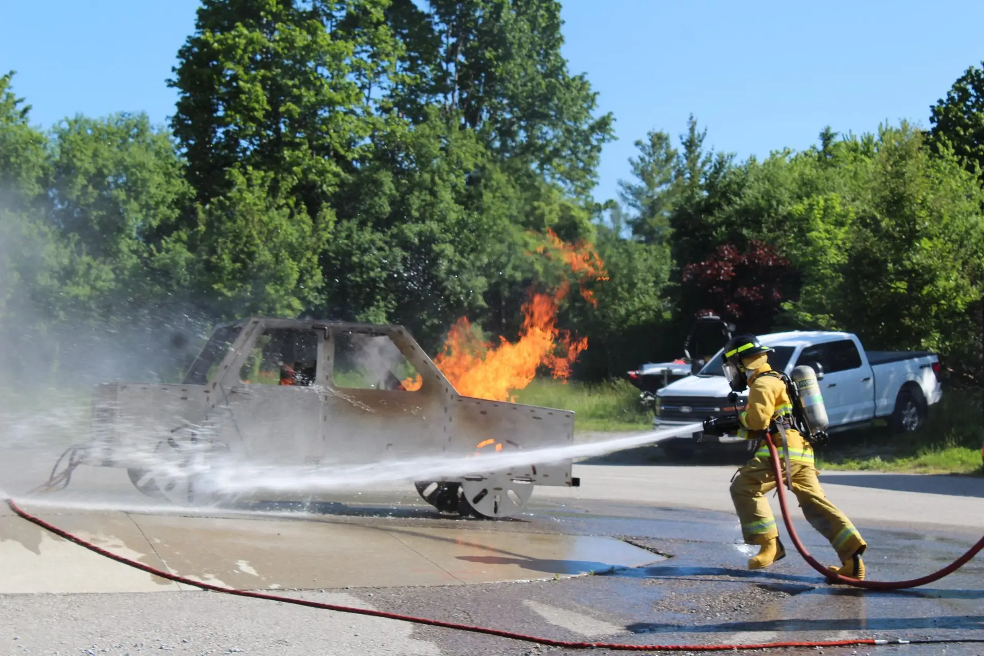 Firefighter extinguishing a vehicle fire during live-fire training